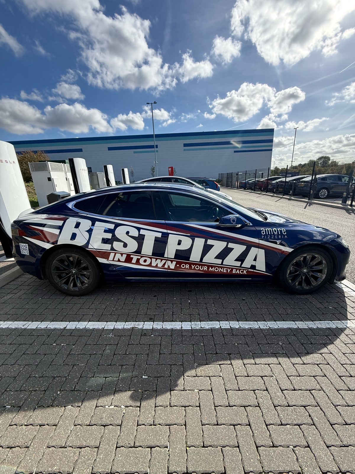 Amore Pizzeria blue car with Best Pizza in Town wrap, side view