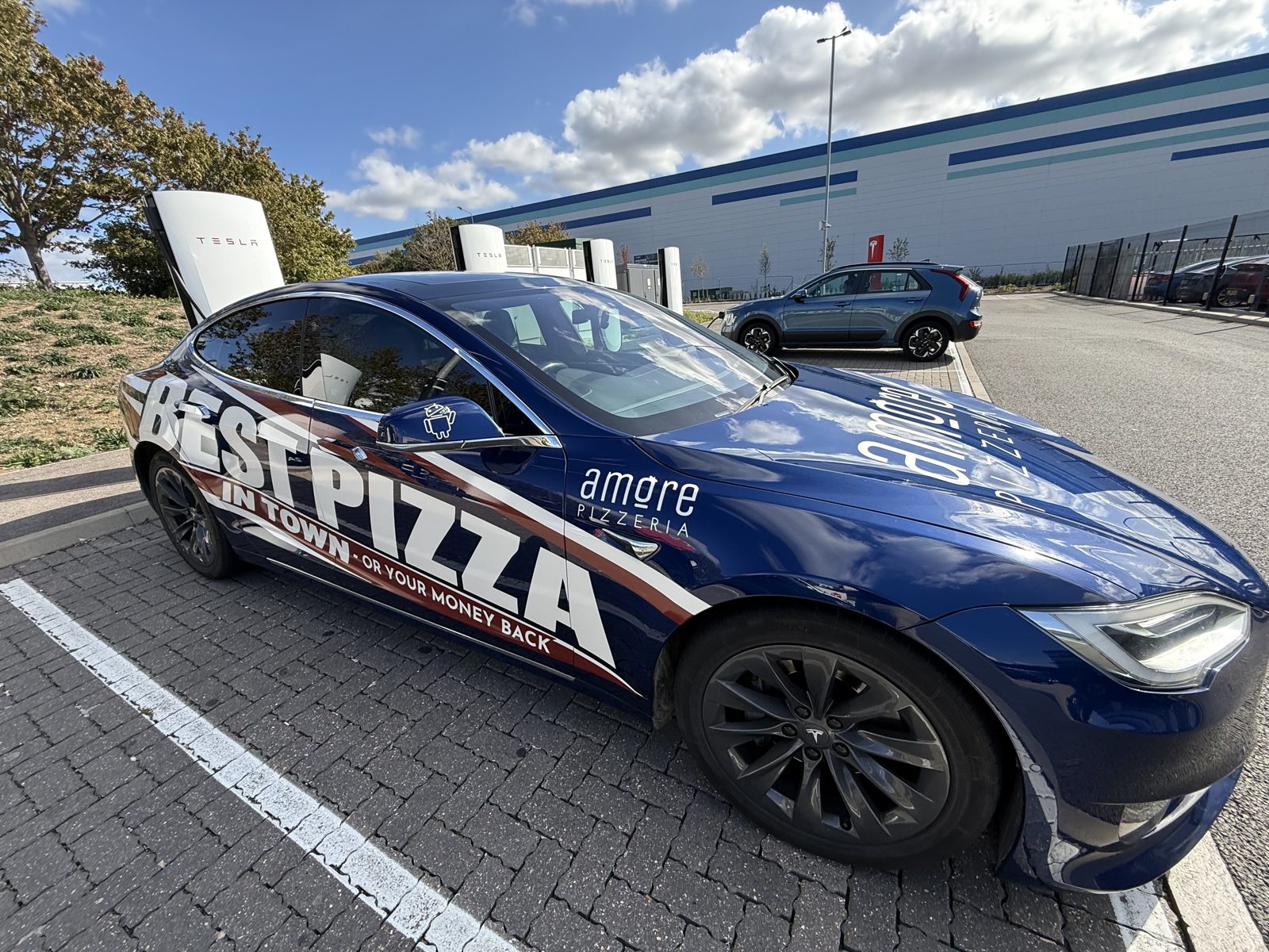 Amore Pizzeria blue car with Best Pizza in Town wrap, front angle